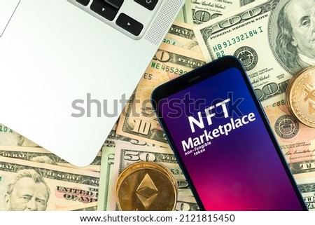NFT cryptoart marketplace background. Smartphone with NFT application on money background with golden crypto currency coins, top view