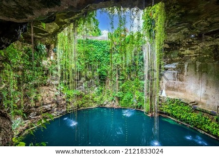 Ik-Kil Cenote, Mexico. Lovely cenote in Yucatan Peninsulla with transparent waters and hanging roots. Chichen Itza, Central America. Royalty-Free Stock Photo #2121833024