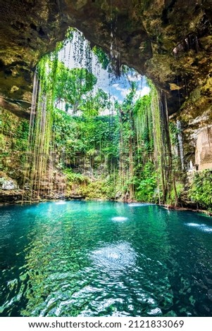 Ik-Kil Cenote, Mexico. Lovely cenote in Yucatan Peninsulla with transparent waters and hanging roots. Chichen Itza, Central America. Royalty-Free Stock Photo #2121833069