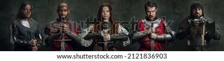 Oath. Collage with portraits of serious medieval warriors or knights with wounded faces holding swords isolated over dark vintage background. Comparison of eras, history, fashion, safe Royalty-Free Stock Photo #2121836903