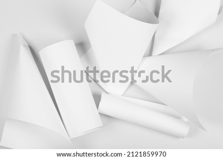 White sheets of office paper are twisted and scattered. Paper white abstract background.