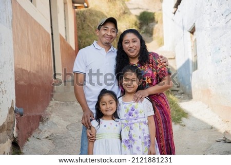 Hispanic family outside their house - Guatemalan family in the alley of their neighborhood Royalty-Free Stock Photo #2121881231