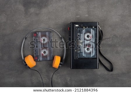 Music listening concept. Vintage cassette tape, audio player and headphones close-up on grey concrete background, top view. Royalty-Free Stock Photo #2121884396