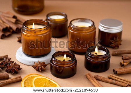 A set of different aroma candles in brown glass jars. Scented handmade candle. Soy candles are burning in a jar. Aromatherapy and relax in spa and home. Royalty-Free Stock Photo #2121894530