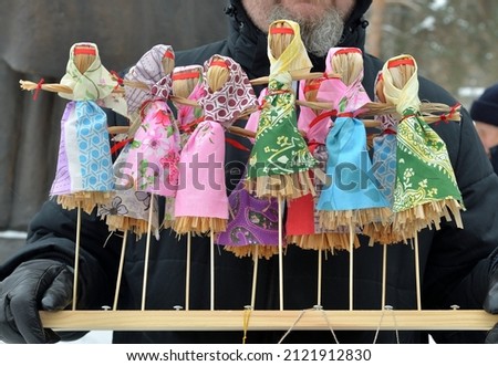 Toy effigies of Shrove Tuesday made of straw on wooden stand at Maslenitsa (Butter Lady, Butter Week, Crepe week, or Cheesefare Week) celebrations, Eastern Slavic religious and folk holiday, Russia Royalty-Free Stock Photo #2121912830