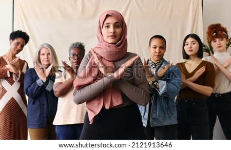 Middle Eastern woman wearing hajib gesturing Break The Bias in support of International Women's Day with female friends Royalty-Free Stock Photo #2121913646