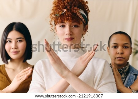 Young white woman gesturing Break The Bias in support of International Women's Day with multi ethnic female friends Royalty-Free Stock Photo #2121916307