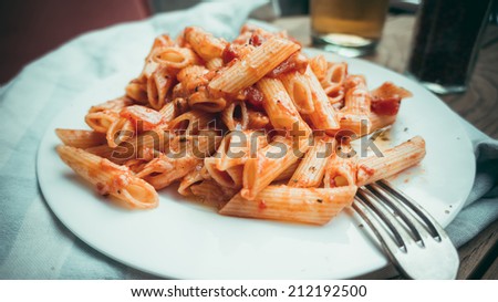 Penne pasta with tomato sauce arrabiata and cheese parmesan. Toned picture