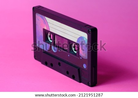 Vintage audio cassette isolated in perspective. Pink background. Warm light