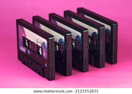Vintage audio cassettes. Pattern. Pink background. Warm light