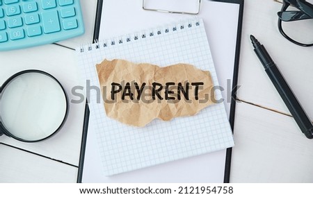 PAY RENT text on the notebook with chart, magnifier,keyboard and pen