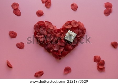 Valentine's day heart made with rose petals and gift box Royalty-Free Stock Photo #2121973529
