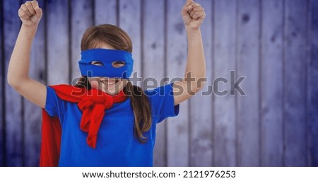 Composite image of caucasian girl in superhero costume against blue textured background. women empowerment concept