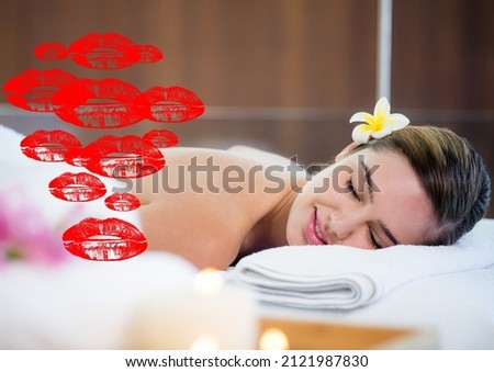 Multiple red lipstick stains icons against woman receiving a massage at a spa. beauty spa treatment and relaxation concept