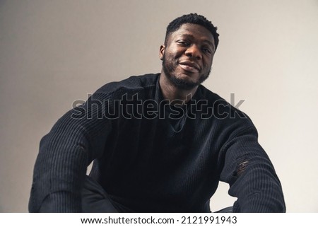 smiling black men sitting looking at the camera white background - portrait shot. High-quality photo