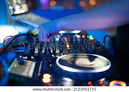 Dj mixing at party festival with light and smoke in background - Summer nightlife view of disco club inside. 