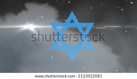 Digital composite image of blue star of david against cloud in sky at night. jew symbol and culture.