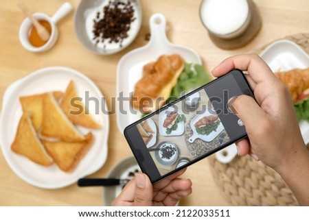 Using a smart phone to photograph food on a wooden table