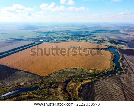 Panoramic view from a drone, aerial photography of the landscape with abstract agricultural fields of crops and soul, village infrastructure, Geometric shapes on farm fields