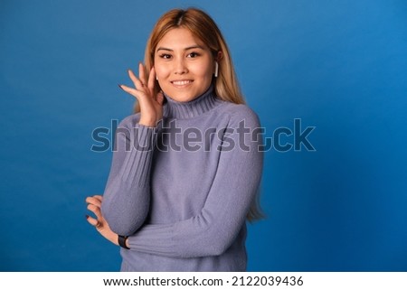 A woman of Asian appearance on a blue background