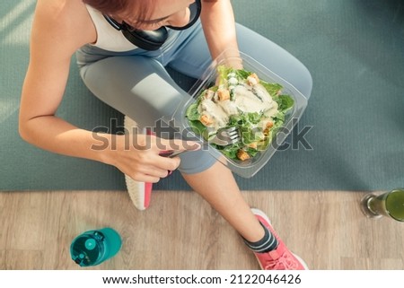 Top view selective focus on hand of sport female bowl vegetable salad healthy food. Fitness sport woman in sportswear healthy eating vegetable salad in the bowl. Dieting and exercise concept.