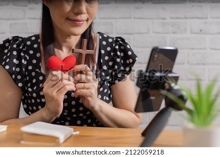 Asian woman having video call on laptop, shows red heart with dating concept.