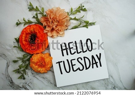Hello Tuesday text with orange flower bouquet on marble background