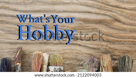 Composite image of what's your hobby text over wooden table with paintbrushes, copy space. national hobby month, hobbies, art and craft concept.