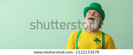 Happy senior man in green hat on light background with space for text. St. Patrick's Day celebration