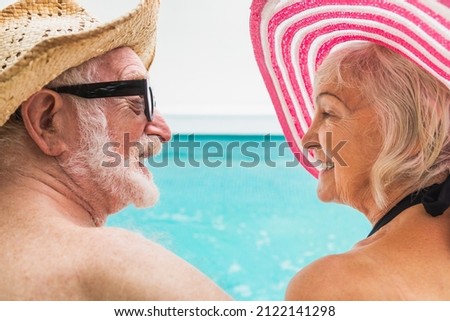 Happy senior couple having party in the swimming pool - Elderly friends releaxing at a pool party during summer vacation Royalty-Free Stock Photo #2122141298