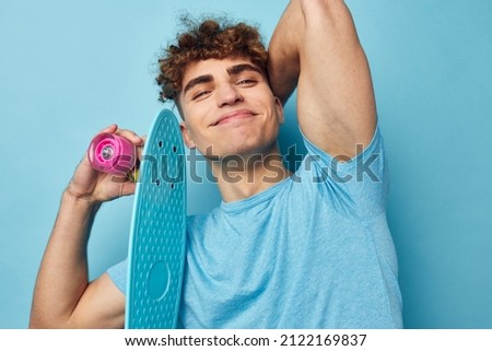 handsome young man skateboard in hand in blue t-shirts unaltered