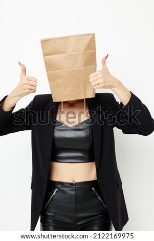 beautiful woman in a leather suit black jacket with a bag on his head isolated background
