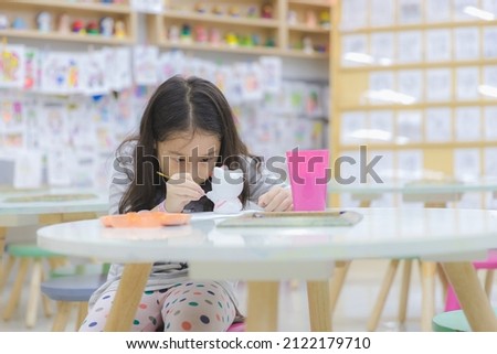 Asian little cute girl paint a cartoon plaster