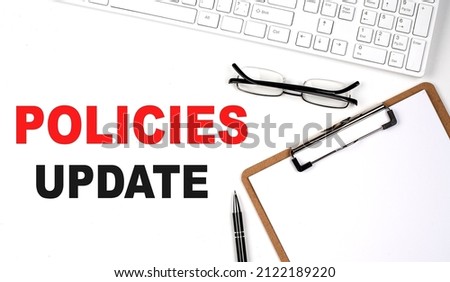Policies Update text written on the white background with keyboard, paper sheet and pen