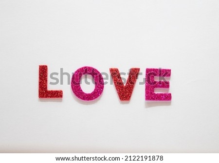 Colored letters with glitter forming the word love, on a white background