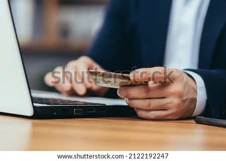 Close-up photo of Asian businessman making online shopping in online store, man using laptop, man holding credit bank card
