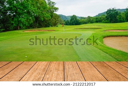 Wooden floor and golf course background. Fresh spring green golf course with wood floor. Beauty natural background, Empty wooden deck table with Green background.                               
