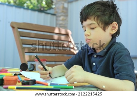 Seriously child boy have drawing outdoor