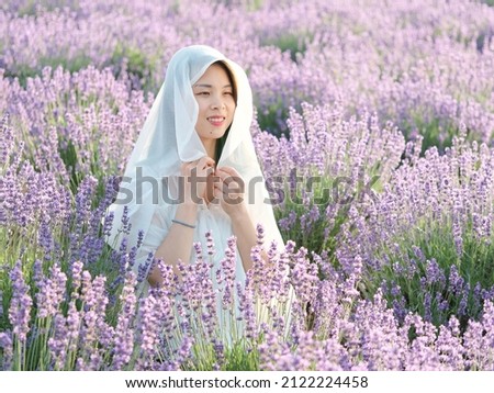 Beautiful Asian young woman model in spring or summer lavender field, Chinese girl enjoy her time in purple flower field in sunny afternoon.