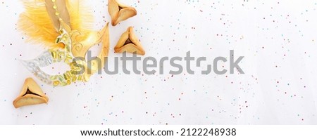 Purim celebration concept (jewish carnival holiday) over white glitter chiffon background. Top view, flat lay