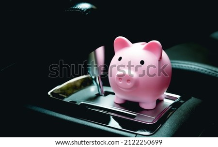 A piggy bank inside a car next to the automatic transmission. Savings concepts for car expenses, car insurance and fuel saving.
 Royalty-Free Stock Photo #2122250699
