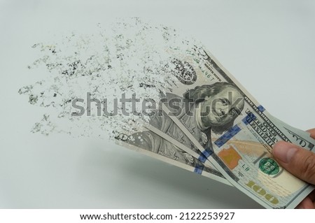 The man's hand holds us dollers, which crushes and flutters in the wind. The concept of currency devaluation and economic crisis.collapse, stagnation economy.Spending and loans,Quarantine coronavirus Royalty-Free Stock Photo #2122253927