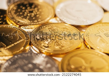 Cardano gold coin against the background of other coins. Electronic virtual cryptocurrency for online banking. Business currency technology concept.