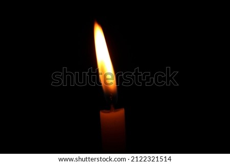burning candle on black background closeup image