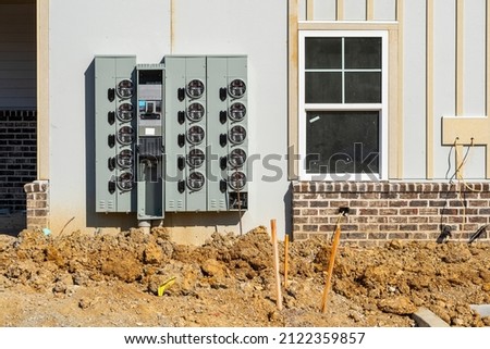 Horizontal shot of new electric meters for apartments under construction.