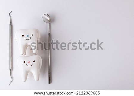 on a white background figurines of teeth and dentist tools.Whitening tooth and dental health on treatment background with cleaning teeth