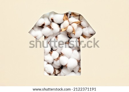 Paper cut t-shirt shape filled with cotton flowers. Organic cotton production, sustainable, ethical shopping, slow, circular fashion concept Royalty-Free Stock Photo #2122371191