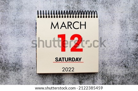 march 12. 12th day of month, calendar date. Stand for desktop calendar on beige wooden background. Concept of day of year, time planner, spring month.