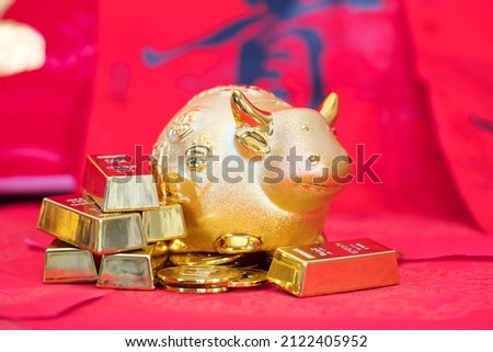 Taurus and gold on red background.The Chinese characters in the picture mean: "to attract wealth and treasure"
