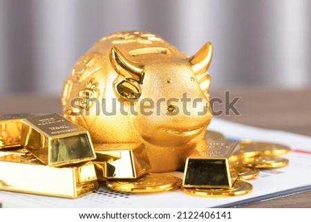 Wealth in the Year of the Ox Golden piggy bank and gold bars.The Chinese characters in the picture mean: "to attract wealth and treasure"
